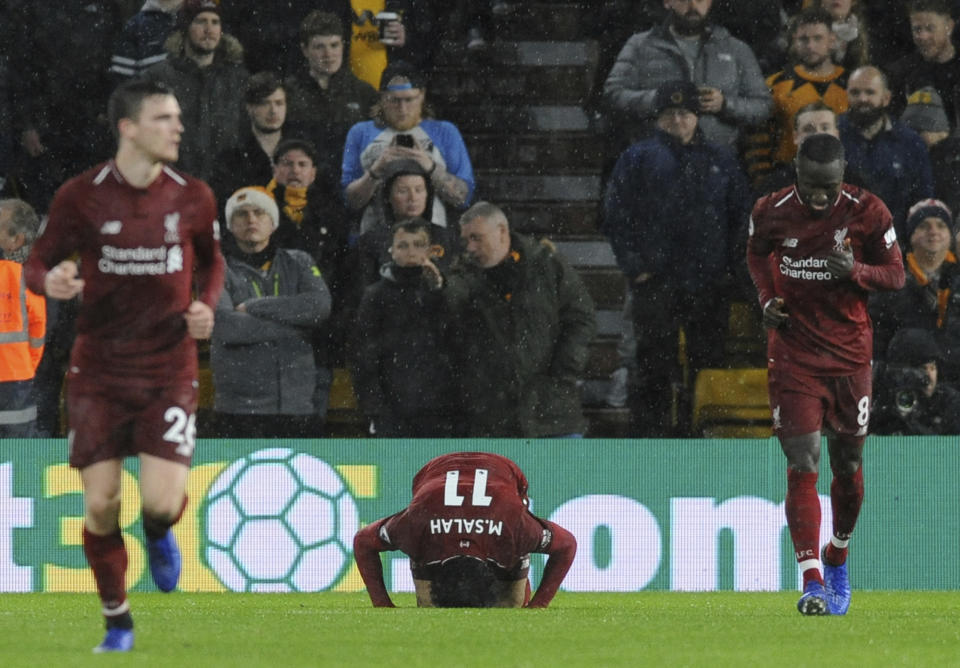 Liverpool's Mohamed Salah, centre, celebrates after scoring his side's opening goal during the English Premier League soccer match between Wolverhampton Wanderers and Liverpool at the Molineux Stadium in Wolverhampton, England, Friday, Dec. 21, 2018. (AP Photo/Rui Vieira)