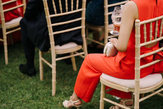 <p>Getty</p> Stock image of a wedding guest seated in a chair on a lawn among other guests