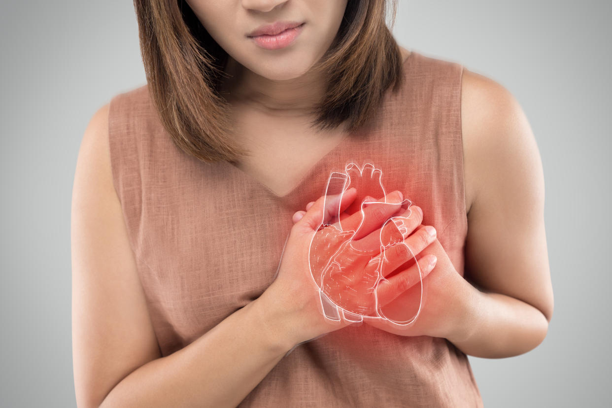 The photo of heart is on the woman's body, Severe heartache, Having heart attack or Painful cramps, Heart disease, Pressing on chest with painful expression.