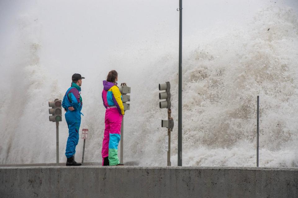 People watch waves crash over the sea wall in Revere, Massachusetts (AFP via Getty)