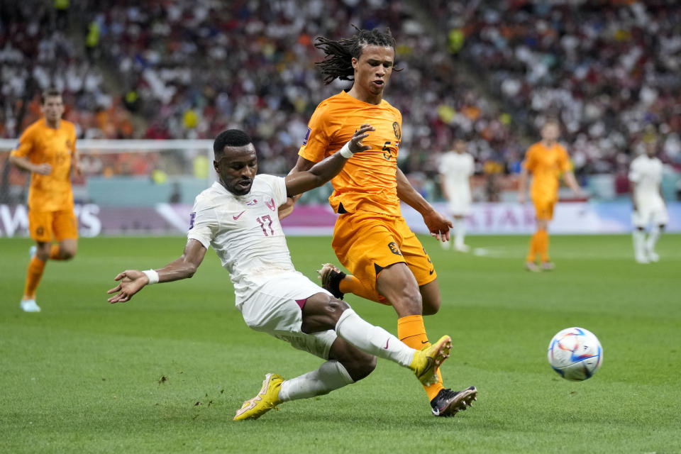 Qatar's Ismail Mohamad and Nathan Ake of the Netherlands vie for the ball during the World Cup group A soccer match between the Netherlands and Qatar, at the Al Bayt Stadium in Al Khor , Qatar, Tuesday, Nov. 29, 2022. (AP Photo/Darko Bandic)