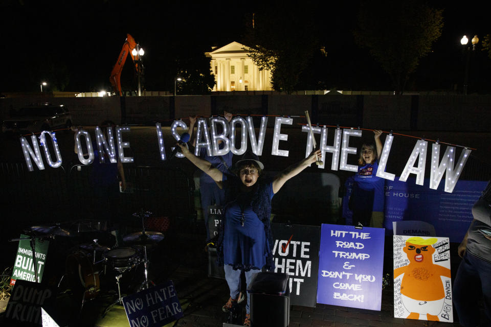 Protesters with Kremlin Annex with a light sign that reads "NO ONE IS ABOVE THE LAW" call to impeach President Donald Trump in Lafayette Square Park in front of the White House in Washington, Thursday, Sept. 26, 2019. (AP Photo/Carolyn Kaster)