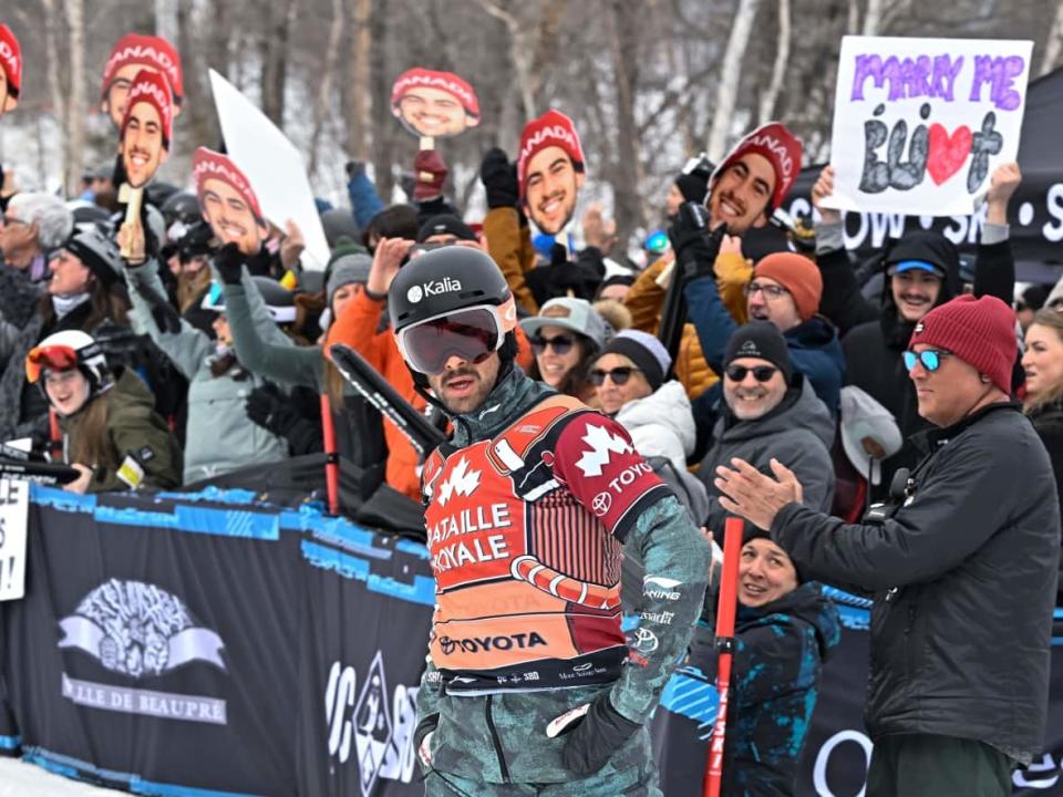 Éliot Grondin of Sainte-Marie, Que., stands in front of his home crowd at the snowboard cross World Cup event at Mont-Sainte-Anne resort in Beaupre, Que. Grondin clinched third overall in the World Cup standings with bronze on Sunday. (Jacques Boissinot/The Canadian Press - image credit)