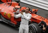 Mercedes driver Lewis Hamilton of Britain holds his red helmet to tribute Niki Lauda after he won the Monaco Formula One Grand Prix race, at the Monaco racetrack, in Monaco, Sunday, May 26, 2019. (AP Photo/Luca Bruno)