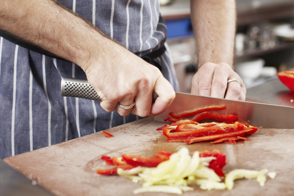 A person cuts vegetables on a cutting board