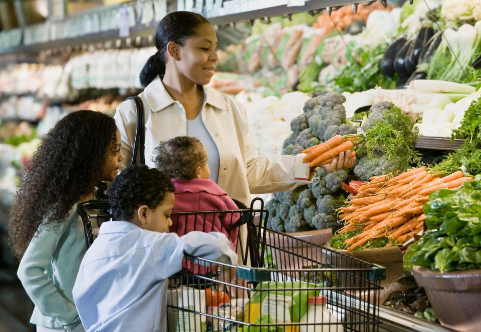 a family shopping for vegetables at the supermarket