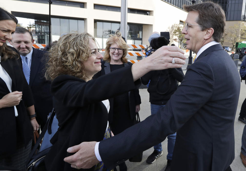 Attorneys Linda Singer and Mark Lanier hug outside the U.S. Federal courthouse, Monday, Oct. 21, 2019, in Cleveland. Both Singer and Lanier are the plaintiffs attorneys. The nation's three dominant drug distributors and a big drugmaker have reached a $260 million deal to settle a lawsuit related to the opioid crisis just as the first federal trial over the crisis was due to begin Monday. (AP Photo/Tony Dejak)