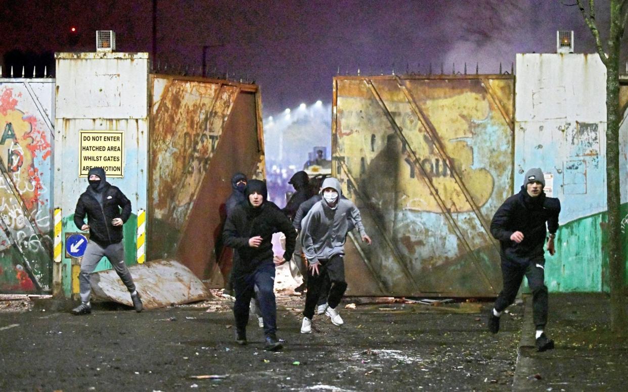 Rioters clashed outside the peace wall that divides east and west Belfast on Wednesday night, the worst night of violence so far - ALAN LEWIS/SPLASH NEWS
