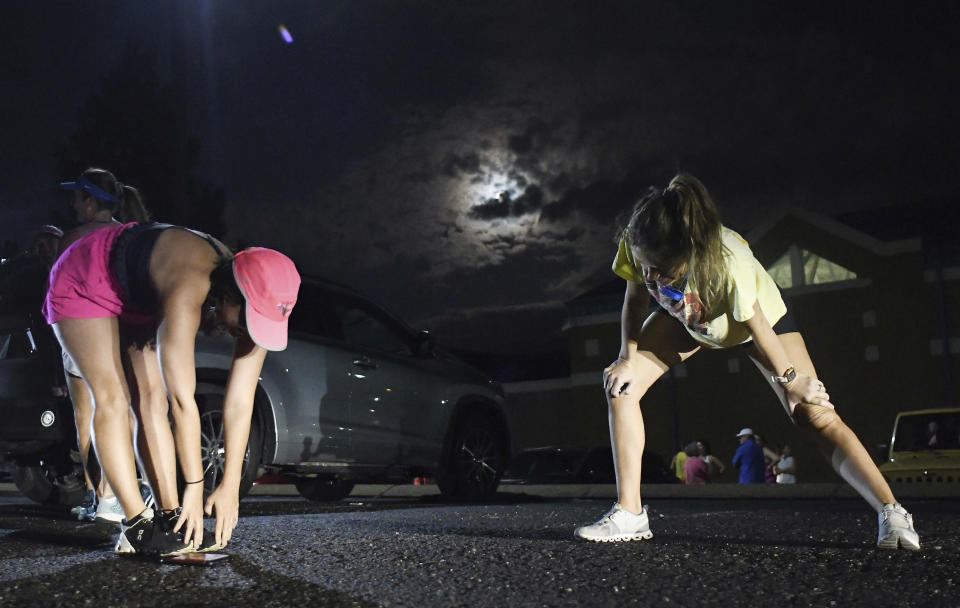 From left, Lauren Pickett and Molly Connolly stretch before taking part in "Finish Eliza's Run" on Friday, Sept. 9, 2022 in Chattanooga, Tenn. The approximately four mile run was to memorialize, Eliza Fletcher, the Memphis runner, and mother of two, who was murdered during her early morning run. (Robin Rudd /Chattanooga Times Free Press via AP)