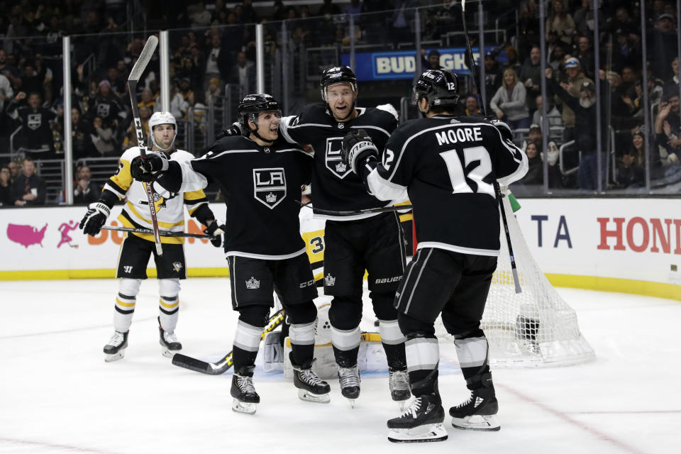 Los Angeles Kings' Trevor Lewis, center, celebrates his goal with Blake Lizotte, left, and Trevor Moore (12) during the second period of an NHL hockey game against the Pittsburgh Penguins Wednesday, Feb. 26, 2020, in Los Angeles. (AP Photo/Marcio Jose Sanchez)