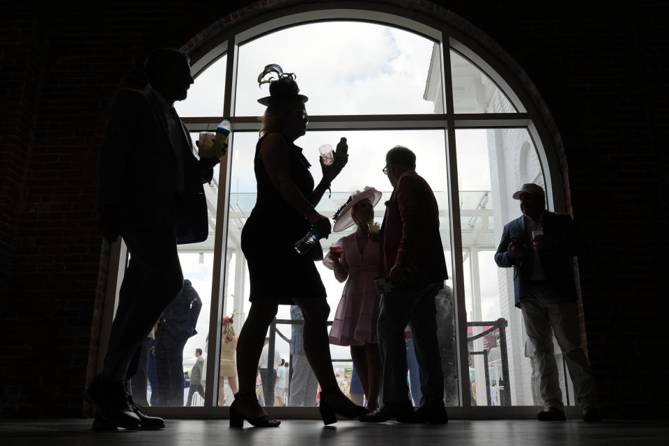 Race fans walk though the grounds of Churchill Downs before the 150th running of the Kentucky Derby horse race Saturday, May 4, 2024, in Louisville, Ky. (AP Photo/Charlie Riedel)