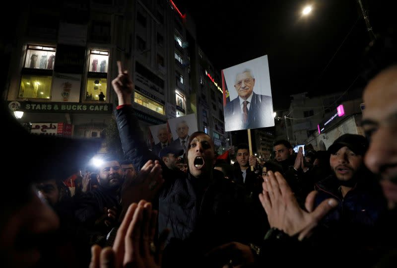 FILE PHOTO: Demonstrators hold pictures of Palestinian President Mahmoud Abbas during a protest against the U.S. President Donald Trump's Mideast peace plan, in Ramallah, in the Israeli-occupied West Bank