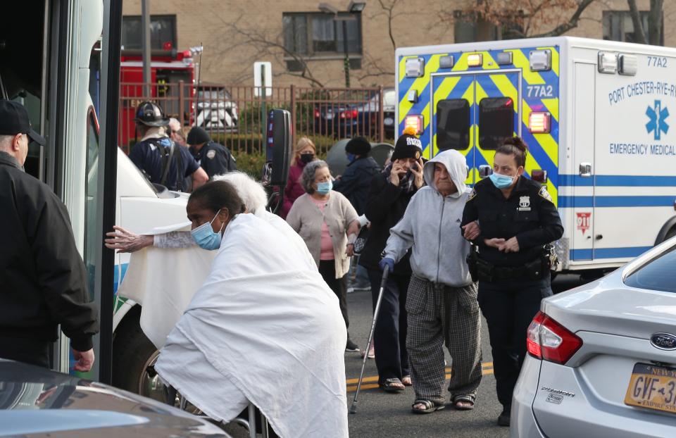 Senior citizens rescued from apartment building fire on King Street in Port Chester are led to a bus to stay warm on Tuesday.