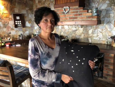 Eugenia Vicuna holds a cushion made from the t-shirt that, she says, her son was wearing at the moment of his detention at their house in El Junquito, Venezuela, February 7, 2019. Picture taken February 7, 2019. To match Insight VENEZUELA-POLITICS/EVIDENCE. REUTERS/Angus Berwick