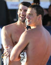 Michael Phelps, left, and Ryan Lochte look toward the crowd after competing in the 100-meter butterfly final during the Arena Grand Prix, Thursday, April 24, 2014, in Mesa, Ariz. Phelps was competing for the first time since the 2012 London Olympics. Lochte finished first and Phelps finished second in the final. (AP Photo/Matt York)