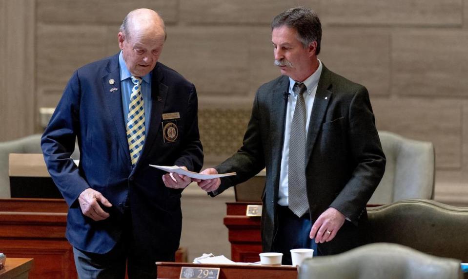 State Sen. Mike Moon, an Ash Grove Republican, right, hands doorkeeper Gil Schellman copies of a proposed bill on Tuesday, March 7, 2023, at the state Capitol in Jefferson City, Mo.