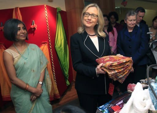 Us Secretary of State Hillary Clinton holds a sari during an Anti-Human Trafficking event in Kolkata. Clinton has called on India to further cut its imports of Iranian oil, saying New Delhi should use its growing clout to help isolate the Islamic republic