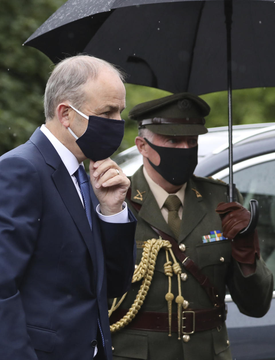 Prime Minster of Ireland Michael Martin arrives to attends the former Northern Ireland lawmaker and Nobel Peace Prize winner John Hume's funeral Mass at St Eugene's Cathedral in Londonderry, Northern Ireland, Wednesday, Aug. 5, 2020. Hume was co-recipient of the 1998 Nobel Peace Prize with fellow Northern Ireland lawmaker David Trimble, for his work in the Peace Process in Northern Ireland. Martin and his aide are wearing masks due to the Coronavirus outbreak. (AP Photo/Peter Morrison)