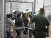 <p>A U.S. Border Patrol agent watches as people who’ve been taken into custody related to cases of illegal entry into the United States, stand in line at a facility in McAllen, Texas, Sunday, June 17, 2018. (Photo: U.S. Customs and Border Protection’s Rio Grande Valley Sector via AP) </p>