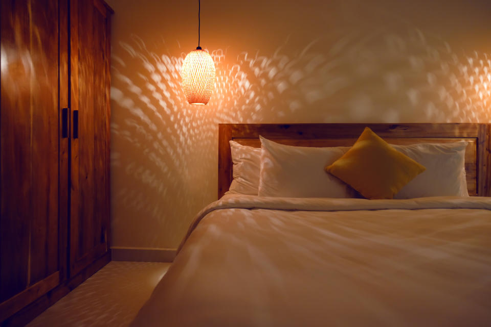 Beautiful interior of tropical luxurious resort room in Asia. Low light and shadows on wall and bed create relaxing mood and atmosphere. Staycation getaway perfect.