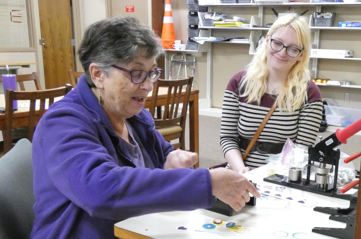 Cindy Bonwell of rural Galion, left, learns how to use the button-maker at the Bucyrus Public Library with help from Rebecca Adler. Bonwell said she is new to the area and came over to the library to explore.