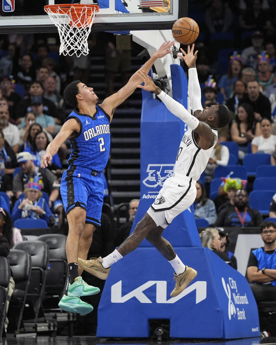 Brooklyn Nets guard Dennis Schroder makes a shot over Orlando Magic guard Caleb Houstan (2) during the first half of an NBA basketball game, Tuesday, Feb. 27, 2024, in Orlando, Fla. (AP Photo/John Raoux)