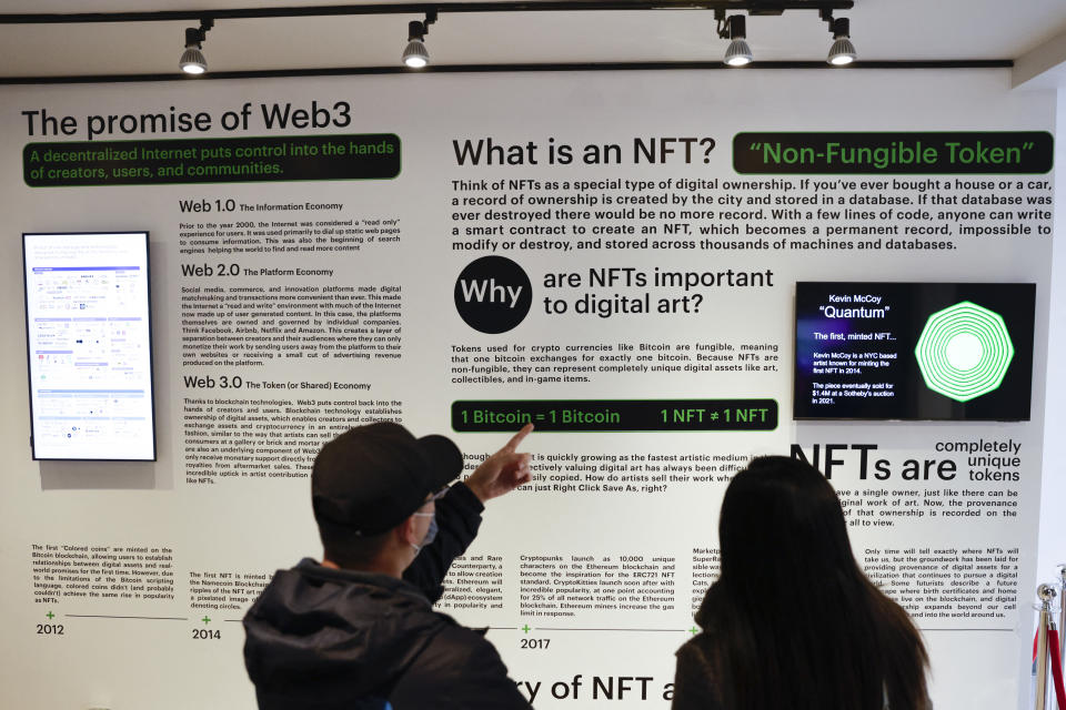 Visitors read about Non-Fungible Tokens, or NFTs, during the opening weekend of the Seattle NFT Museum in Seattle, Washington on January 29, 2022. - Using the blockchain technology behind cryptocurrencies, Non-fungible tokens (NFTs) transform anything from illustrations to memes into virtual collectors' items that cannot be duplicated. (Photo by Jason Redmond / AFP) (Photo by JASON REDMOND/AFP via Getty Images)