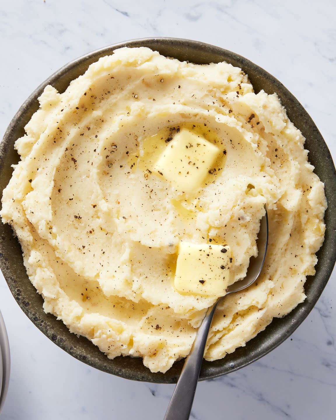 slow cooker mashed potatoes with a pat of butter, salt, and pepper