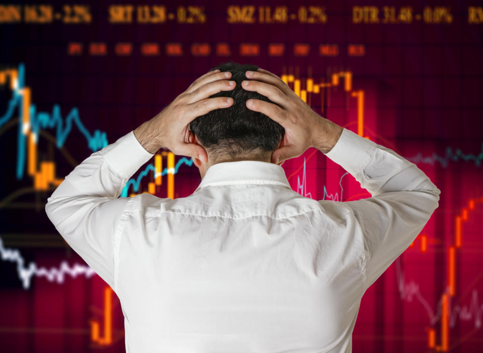 A stock broker panics looking at a falling chart