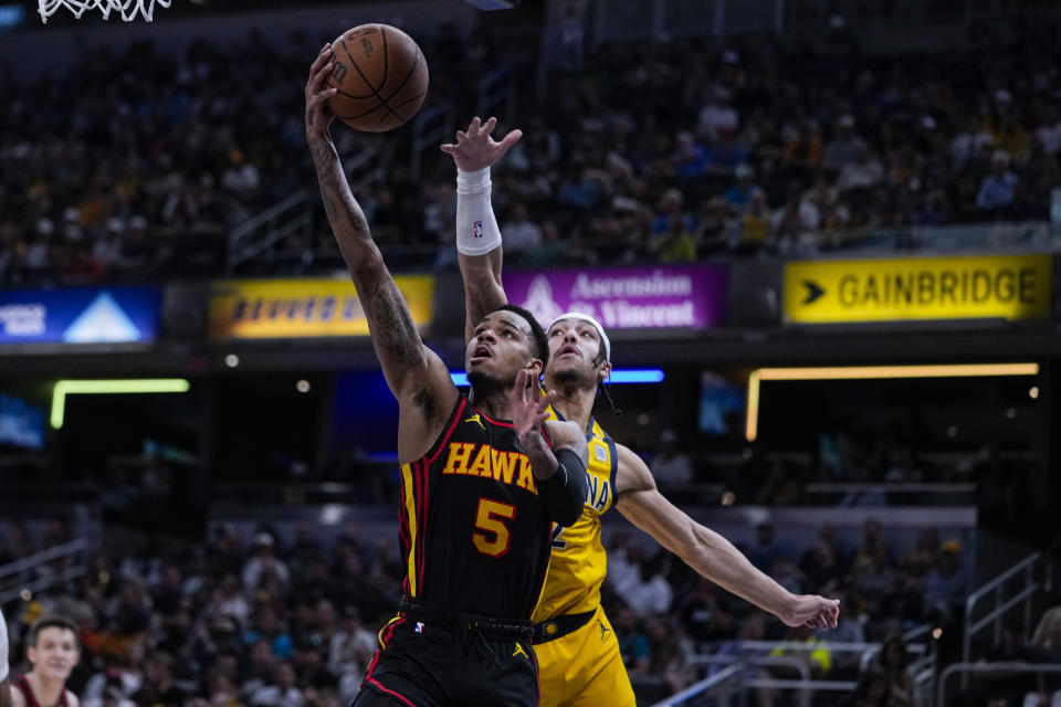 Atlanta Hawks guard Dejounte Murray (5) shoots in front of Indiana Pacers guard Andrew Nembhard (2) during the first half of an NBA basketball game in Indianapolis, Sunday, April 14, 2024. (AP Photo/Michael Conroy)