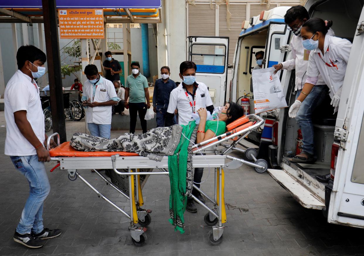 <p>A patient is wheeled inside a Covid-19 hospital for treatment in Ahmedabad on Wednesday</p> (REUTERS)