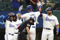 Texas Rangers' Nate Lowe (30) is greeted by Willie Calhoun (5), Adolis Garcia (53) and Joey Gallo (13) after hitting a three-run home run against the Los Angeles Angels in the first inning of a baseball game Monday, April 26, 2021, in Arlington, Texas. (AP Photo/Richard W. Rodriguez)