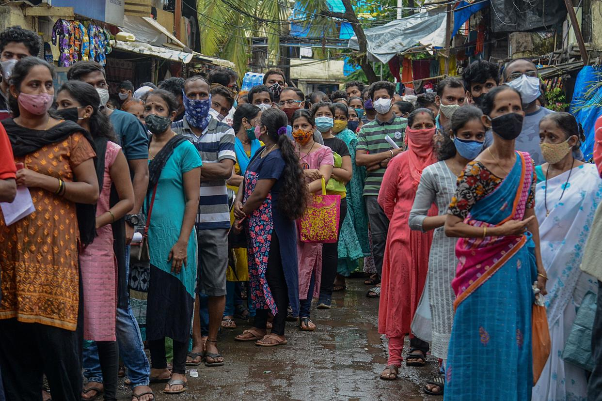 People queue up to get themselves inoculated at a residential settlement in Mumbai on 2 August 2021 (AFP via Getty Images)