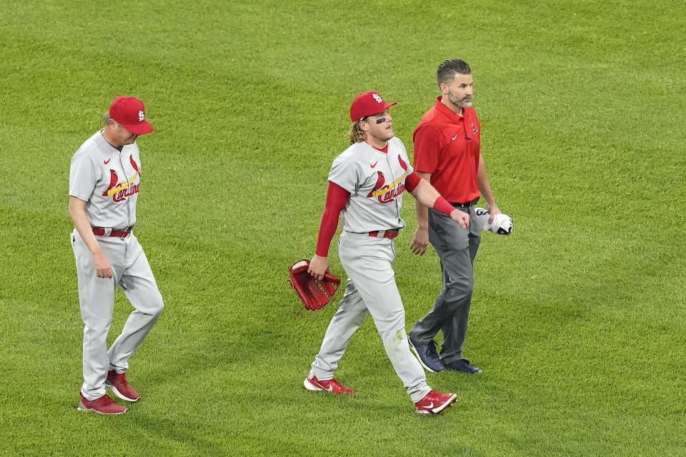 St. Louis Cardinals' Harrison Bader, center, leaves the game with manager Mike Shildt, left, and a member of the training staff after Bader was unable to make a diving catch of a shallow fly ball by Chicago White Sox's Nick Madrigal during the third inning of an interleague baseball game Monday, May 24, 2021, in Chicago. (AP Photo/Charles Rex Arbogast)