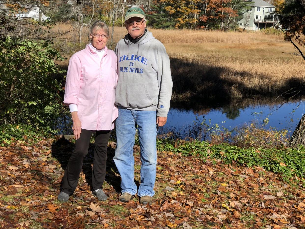 Gayle and David Spofford are seen in their back yard along the Mousam River on Summer Street in Kennebunk, Maine, on Oct. 31, 2023. They are opposing attempts by their neighbors, Hunt and Katie Edwards, to secure a contract zone for the historic Wedding Cake House.
