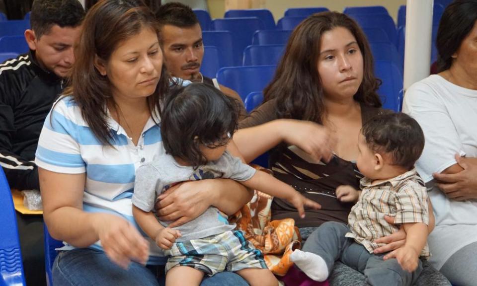 Mothers and children wait to be assisted by volunteers at a humanitarian center in the border town of McAllen, Texas on Friday.