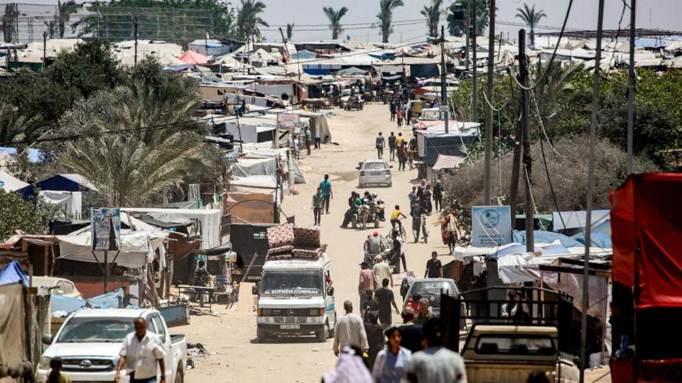 PHOTO: Vehicles move about past the tents and shelters of people displaced by conflict in the western part of Rafah in the southern Gaza Strip, June 14, 2024. (Bashar Taleb/AFP via Getty Images)