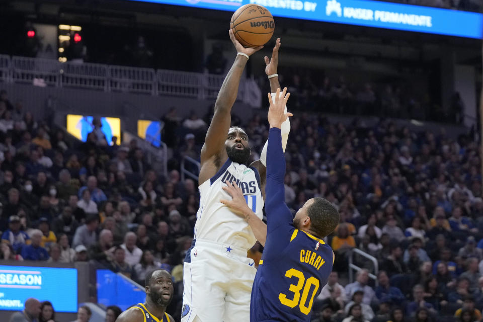 Dallas Mavericks forward Tim Hardaway Jr., top, shoots against Golden State Warriors guard Stephen Curry (30) during the first half of an NBA basketball game in San Francisco, Saturday, Feb. 4, 2023. (AP Photo/Jeff Chiu)