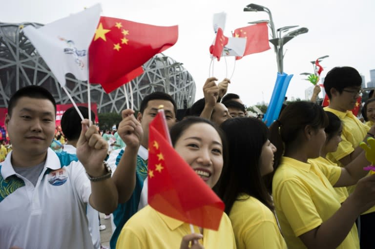 Volunteers parade in front of journalists in Beijing to celebrate the announcement by the International Olympic Committee (IOC) that Beijing had been named to host the 2022 Winter Olympic Games on July 31, 2015