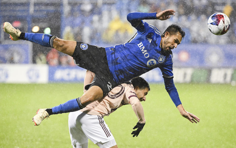 CF Montreal's Mathieu Choiniere, top, challenges Portland Timbers' Sebastian Blanco, bottom, during second-half MLS soccer match action in the rain in Montreal, Saturday, Oct. 7, 2023. (Graham Hughes/The Canadian Press via AP)