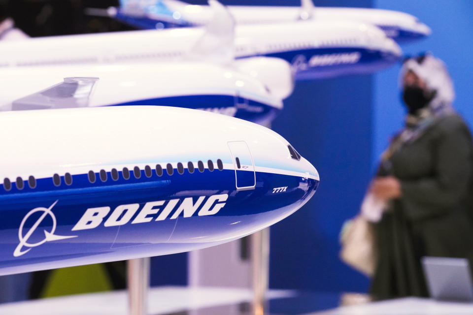 ARQUIVO - Uma mulher passa por modelos de aeronaves da Boeing Co., incluindo o novo Boeing 777X do fabricante, no Dubai Air Show em Dubai, Emirados Árabes Unidos, quarta-feira, 17 de novembro de 2021. A Boeing divulgou lucros na quarta-feira, 31 de janeiro.  , 2024. (AP Photo/Jon Gambrell, Arquivo)