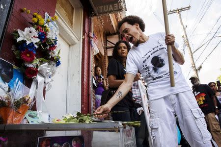 A demonstrator places a rose on a memorial for Eric Garner on the one year anniversary of his death in New York, July 17, 2015. REUTERS/Lucas Jackson