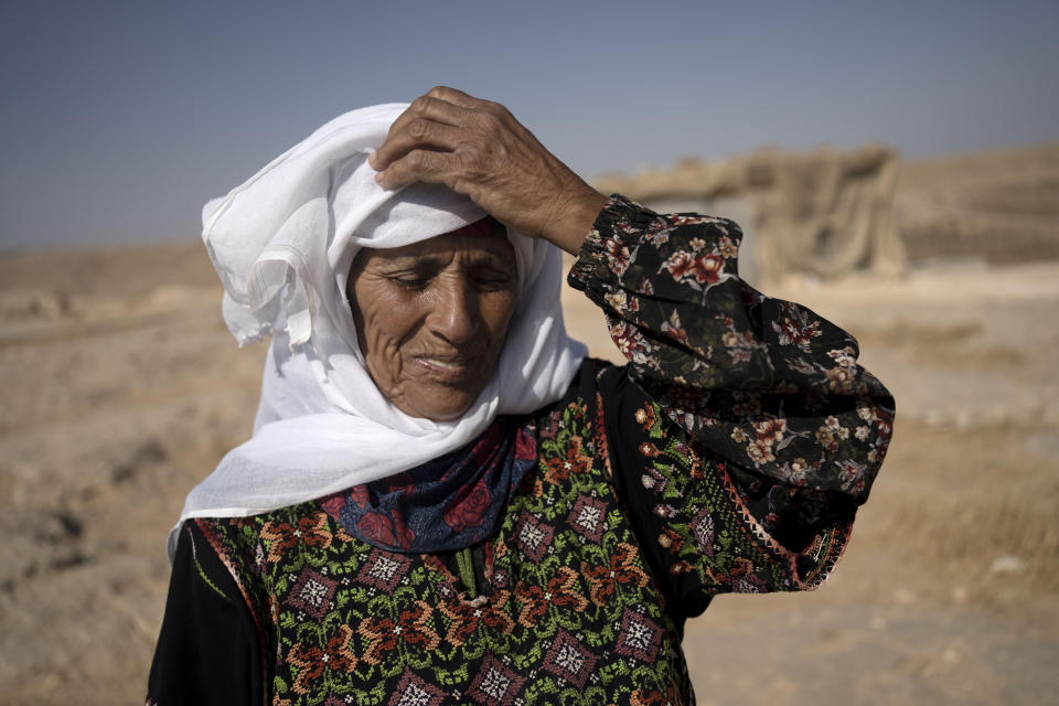 A Palestinian woman poses for a portrait in front of her home in Masafer Yatta, south Hebron hills, Monday, Sept. 4, 2023. The community of herders face expulsion by Israeli authorities and increased attacks by settlers. Residents in the rural area, which the Israeli military plans to seize, say Israeli finance minister Bezalel Smotrich and his allies are squeezing the life from their communities. "We can barely breathe," says one resident. (AP Photo/Maya Alleruzzo)