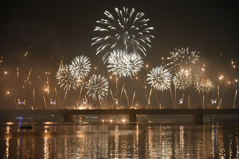 Fireworks explode over a river during New Year celebrations in Abidjan, Ivory Coast