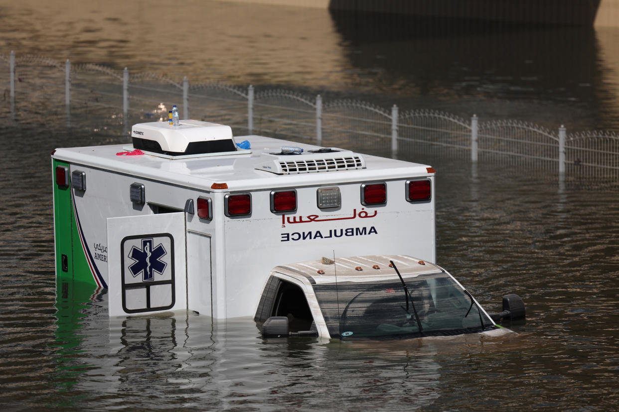 An abandoned ambulance submerged in floodwater on a highway in Dubai.