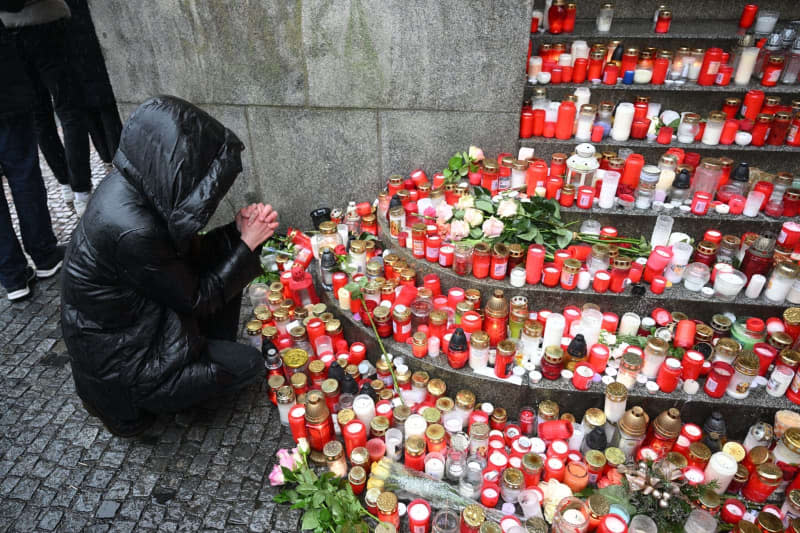 A person pays respects outside the Philosophical Faculty of Charles University following a mass shooting, during the day of national mourning. Kamaryt Michal/CTK/dpa