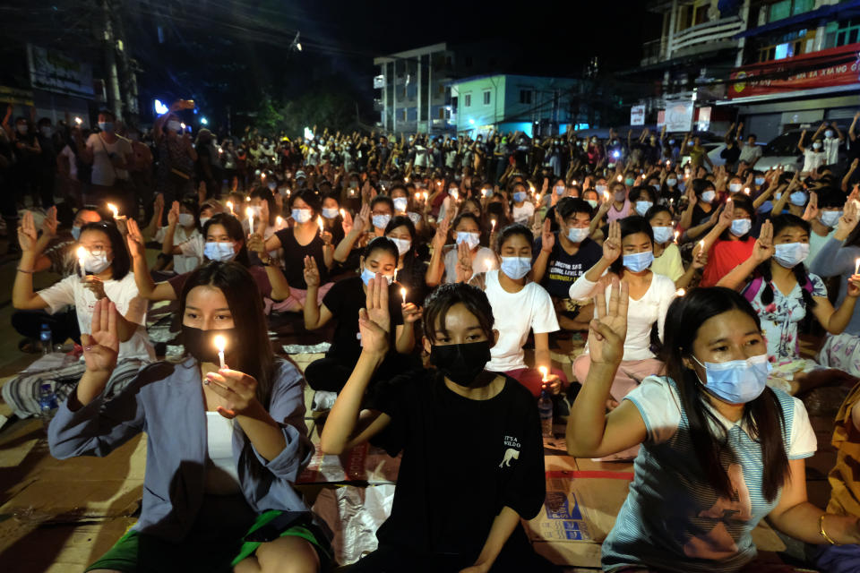Anti-coup protesters flash the three-fingered salute during a candlelight night rally in Yangon, Myanmar Sunday, March 14, 2021. At least four people were shot dead during protests in Myanmar on Sunday, as security forces continued their violent crackdown against dissent following last month's military coup. (AP Photo)