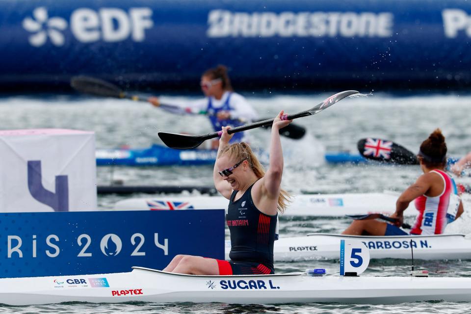 Great Britain's Laura Sugar celebrates in her canoe after winning the KL3 event at Vaires-sur-Marne