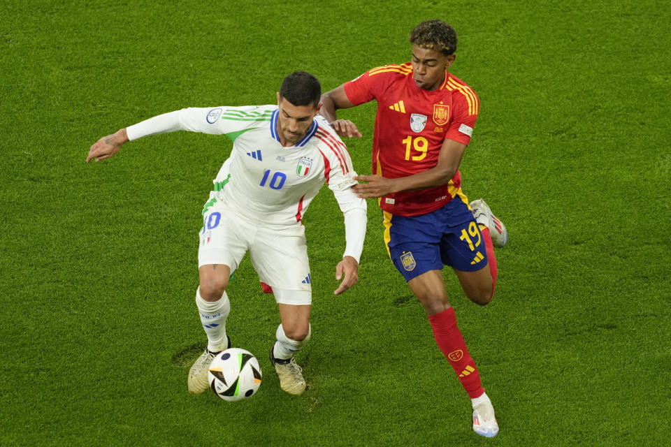 Italy's Lorenzo Pellegrini, left, challenges for the ball with Spain's Lamine Yamal during a Group B match between Spain and Italy at the Euro 2024 soccer tournament in Gelsenkirchen, Germany, Thursday, June 20, 2024. (AP Photo/Andreea Alexandru)