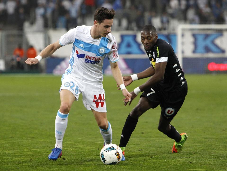 Marseille's Florian Thauvin, left, challenges for the ball with Angers' Karl Toko Ekambi, during the League One soccer match between Marseille and Angers, at the Velodrome Stadium, Friday, March 10, 2017. (AP Photo/Claude Paris)